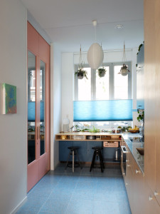 The blue kitchen with contrasting pink sliding doors - Photo by LAGADO architects